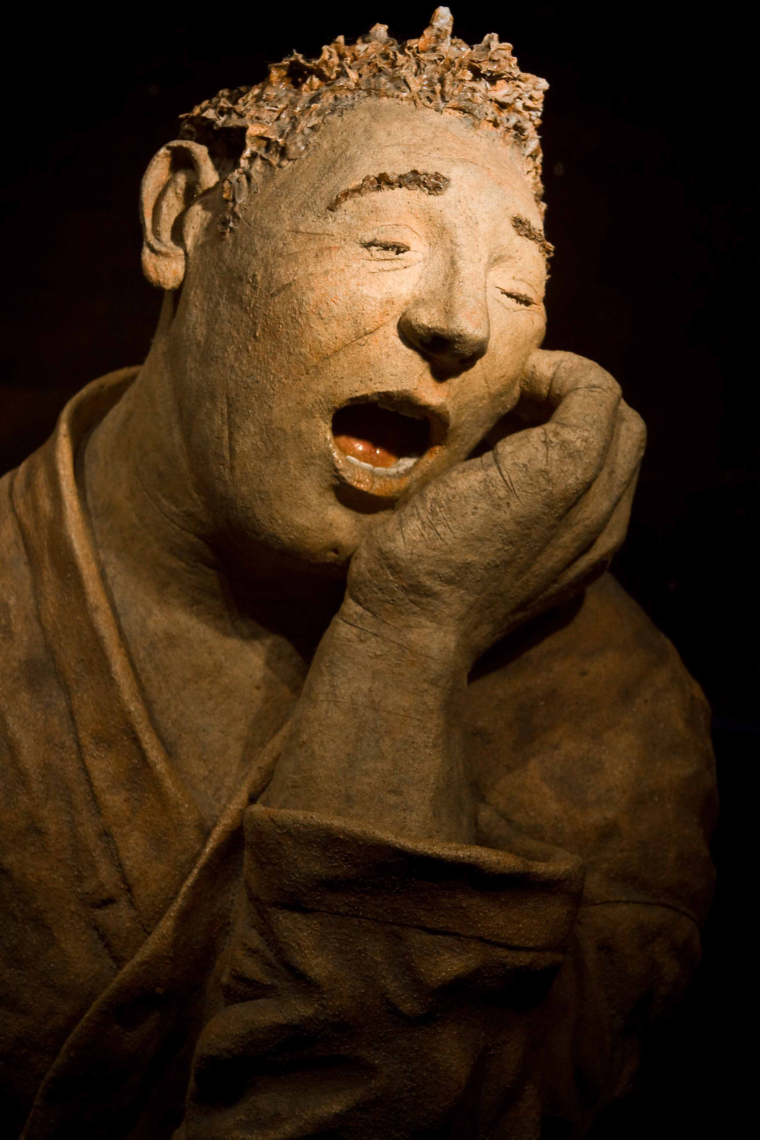 Image of a sculpture of a man with a tooth decay.
