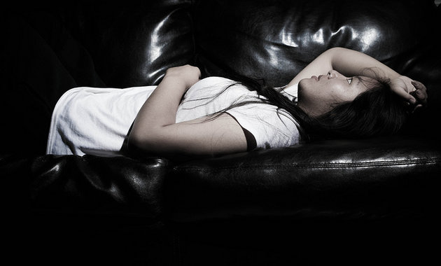 Image of girl lying on a couch stressed about female fertility