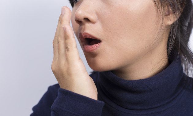 Image of women checking her bad breath