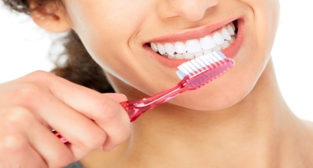 Image of girl brushing her teeth to avoid stained teeth