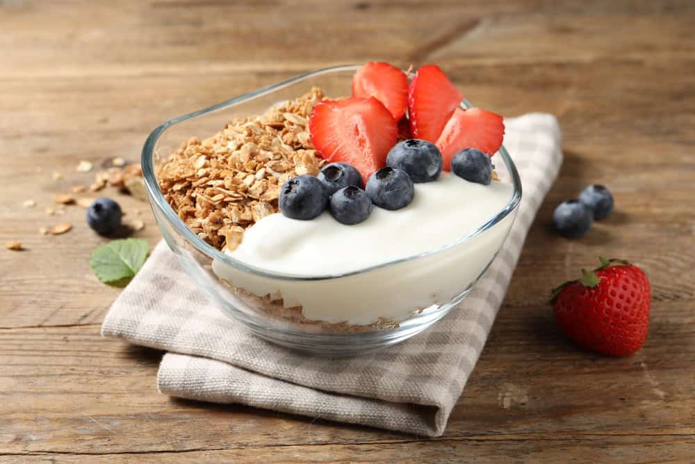 Tasty,Granola,With,Berries,And,Yogurt,In,Bowl,On,Wooden