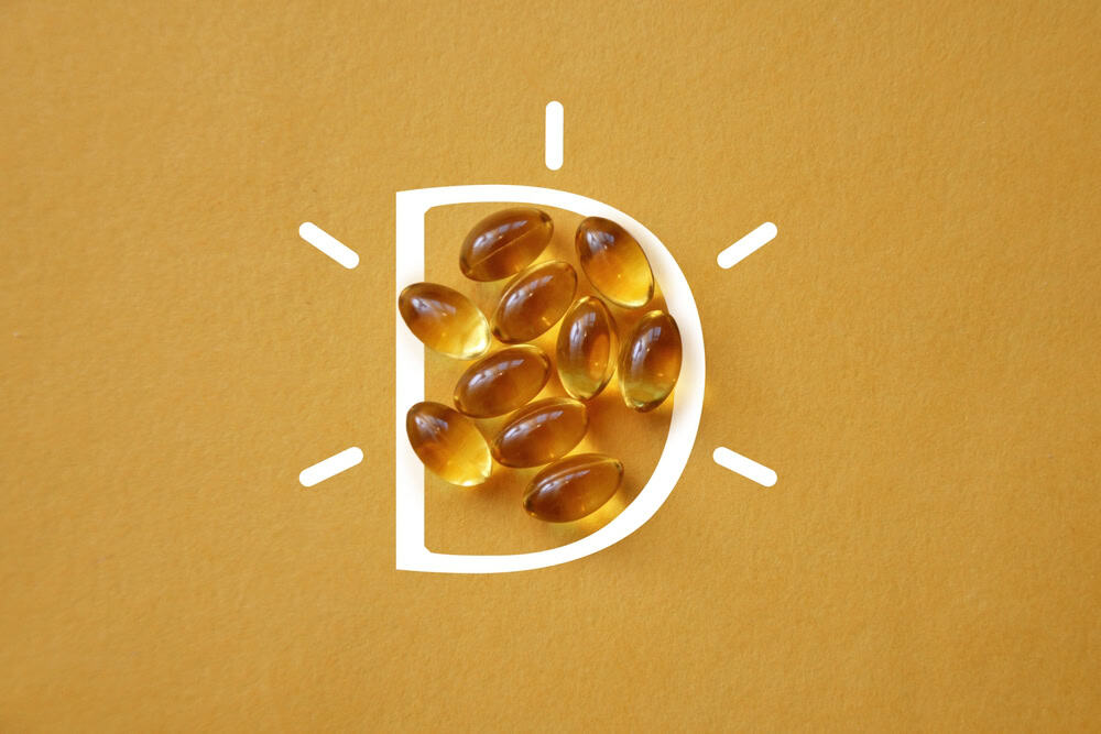 Vitamin,D,In,Capsules,On,A,Yellow,Background
