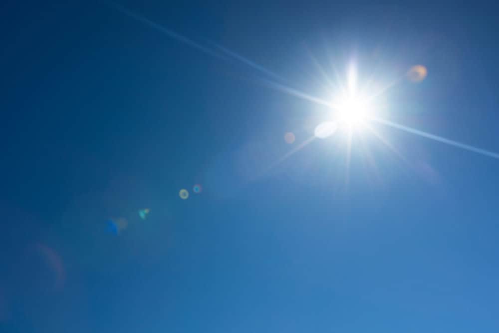 Lens,Flare,Effect,Over,Deep,Blue,Sky,With,Glowing,Sun