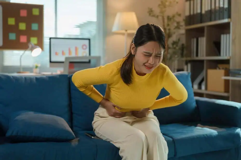 Young,Businesswoman,Is,Experiencing,Severe,Menstrual,Cramps,While,Sitting,On