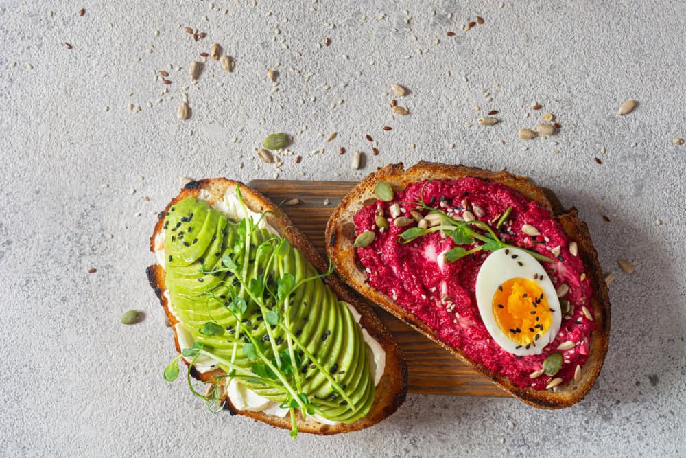 Whole,Grain,Toast,With,Cream,Cheese,,Avocado,,Beetroot,Hummus,,Seeds,
