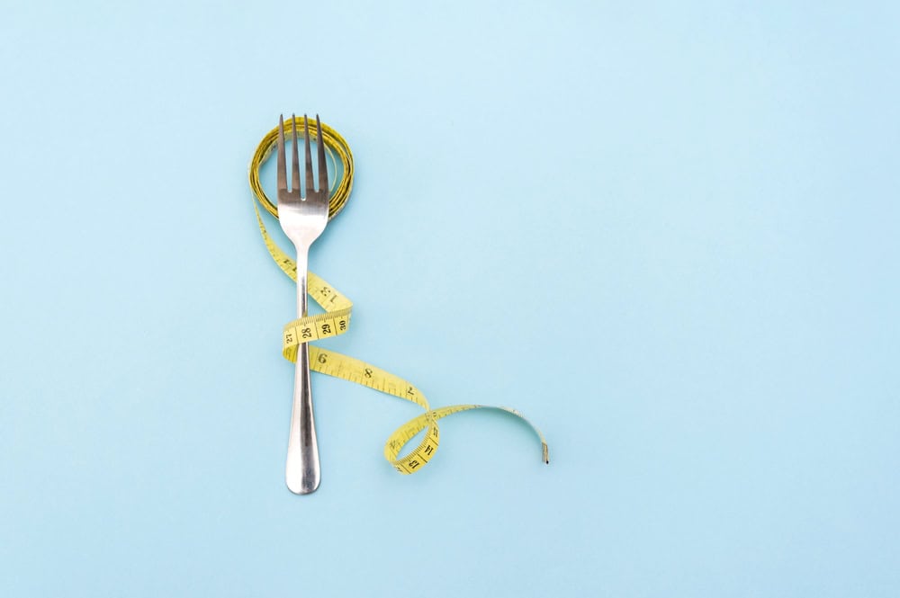 Measuring,Tape,Wrapped,Around,Fork,Symbolizing,Weight,Loss,And,Healthy